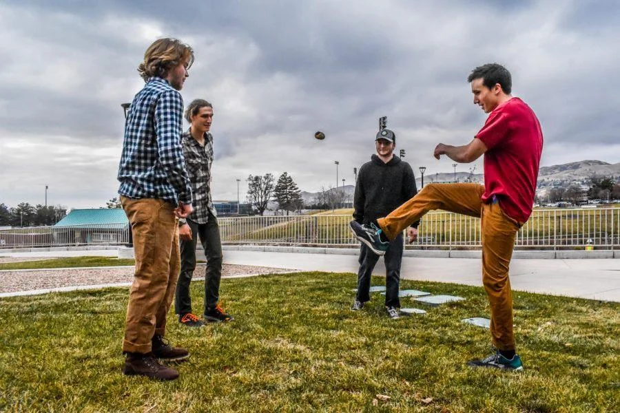 Friends playing hacky sack in a circle outdoors
