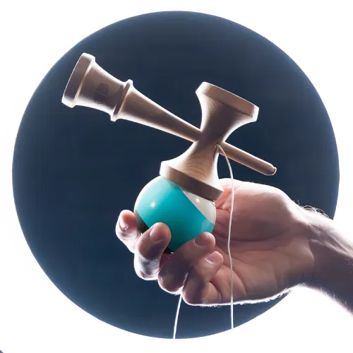 Hand holding a wooden kendama with a teal ball