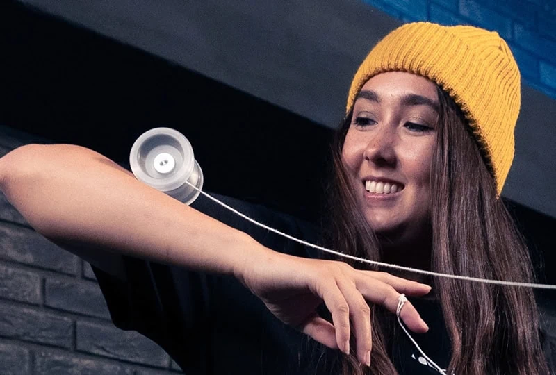 Player in a yellow beanie doing an arm grind with a yoyo