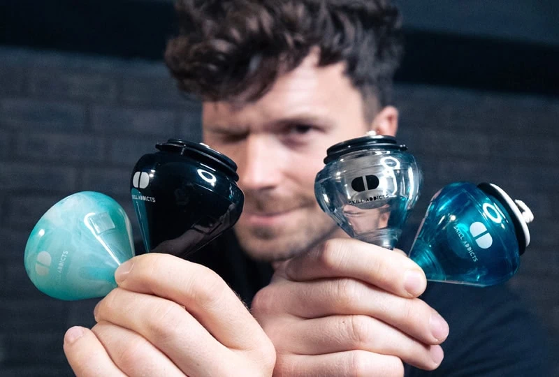Player holding up spin tops of different types