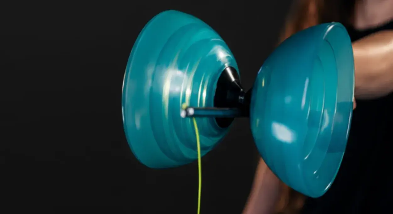 Close-up of a teal Fixed Diabolo spinning on the string