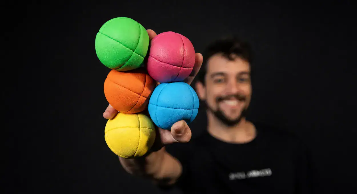 Juggler holding a stack of Infinity Juggling Balls in five colours