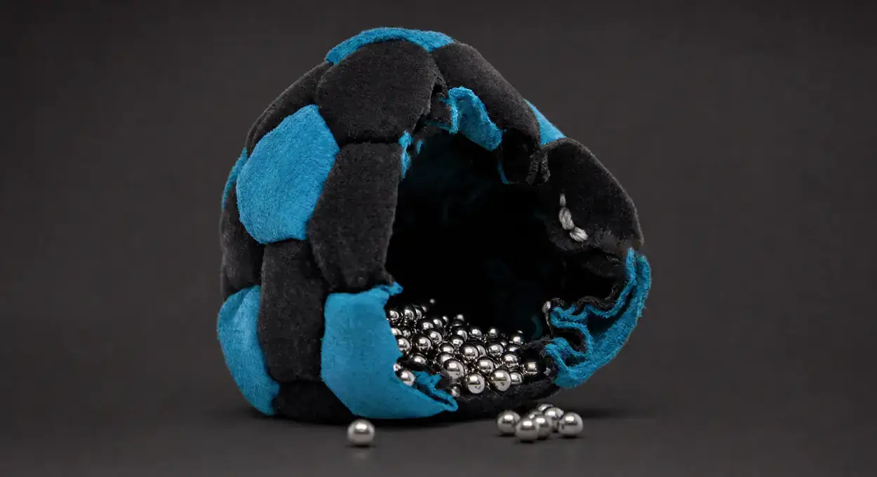 Opened Pro Footbag with its metal bead filling, black background
