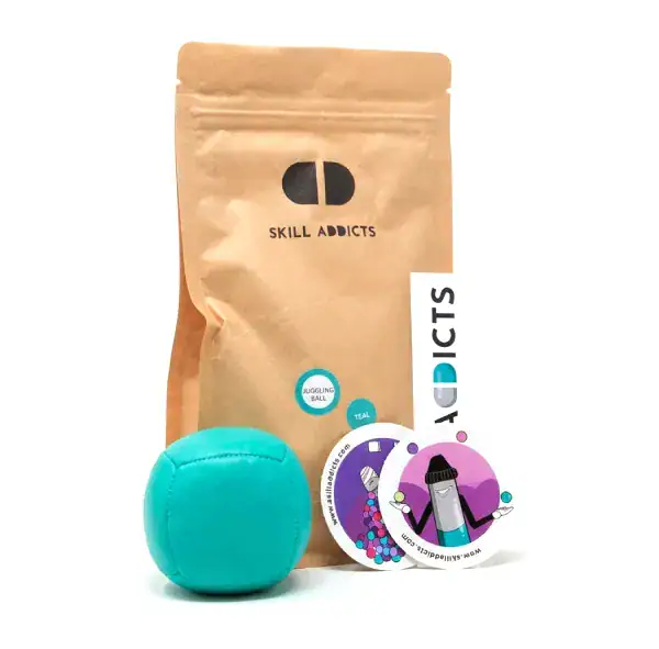 Starter Juggling Ball in teal with its kraft paper bag and stickers